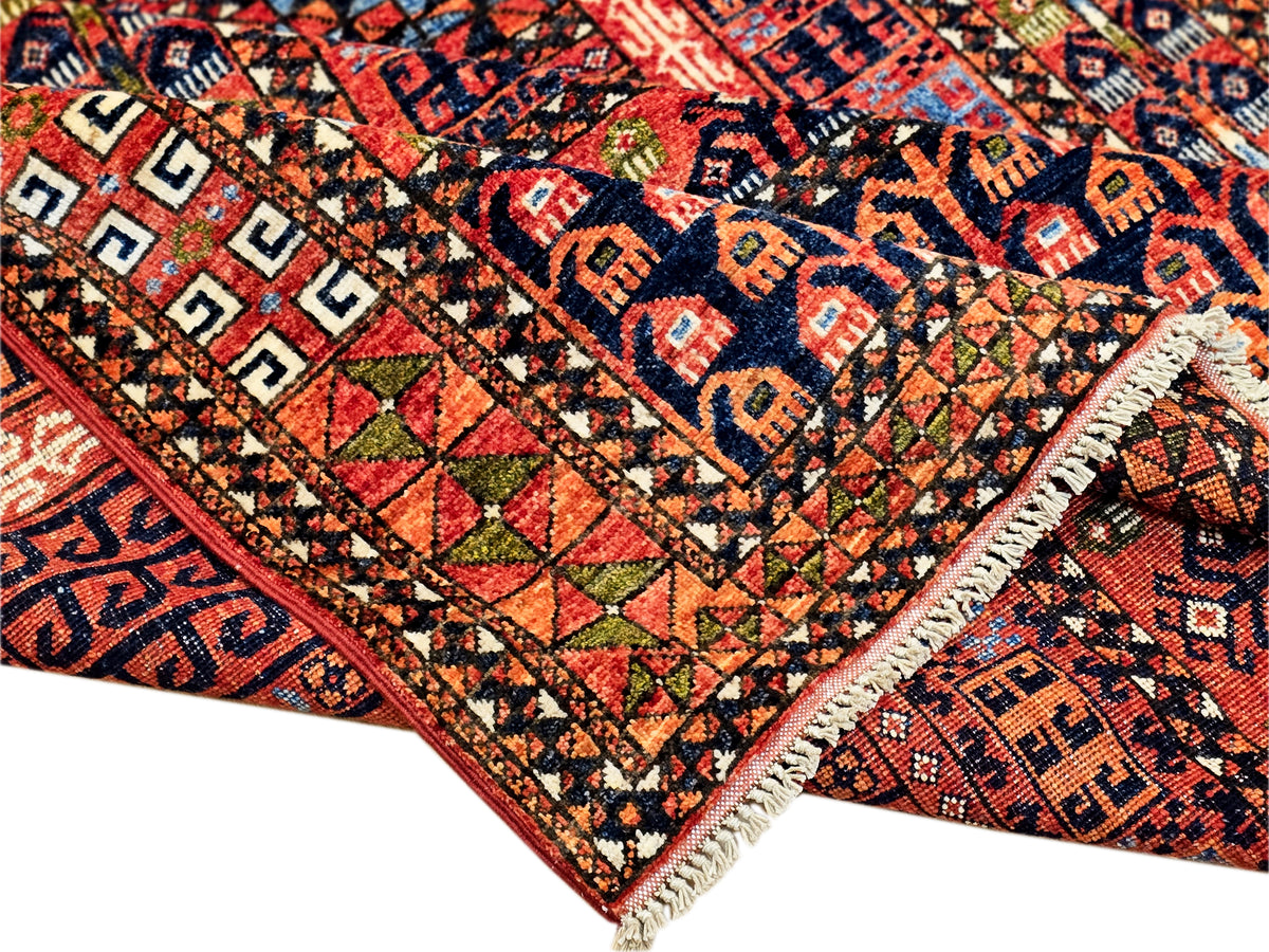 Rug corner with red, navy, and beige geometric pattern and short fringed edge