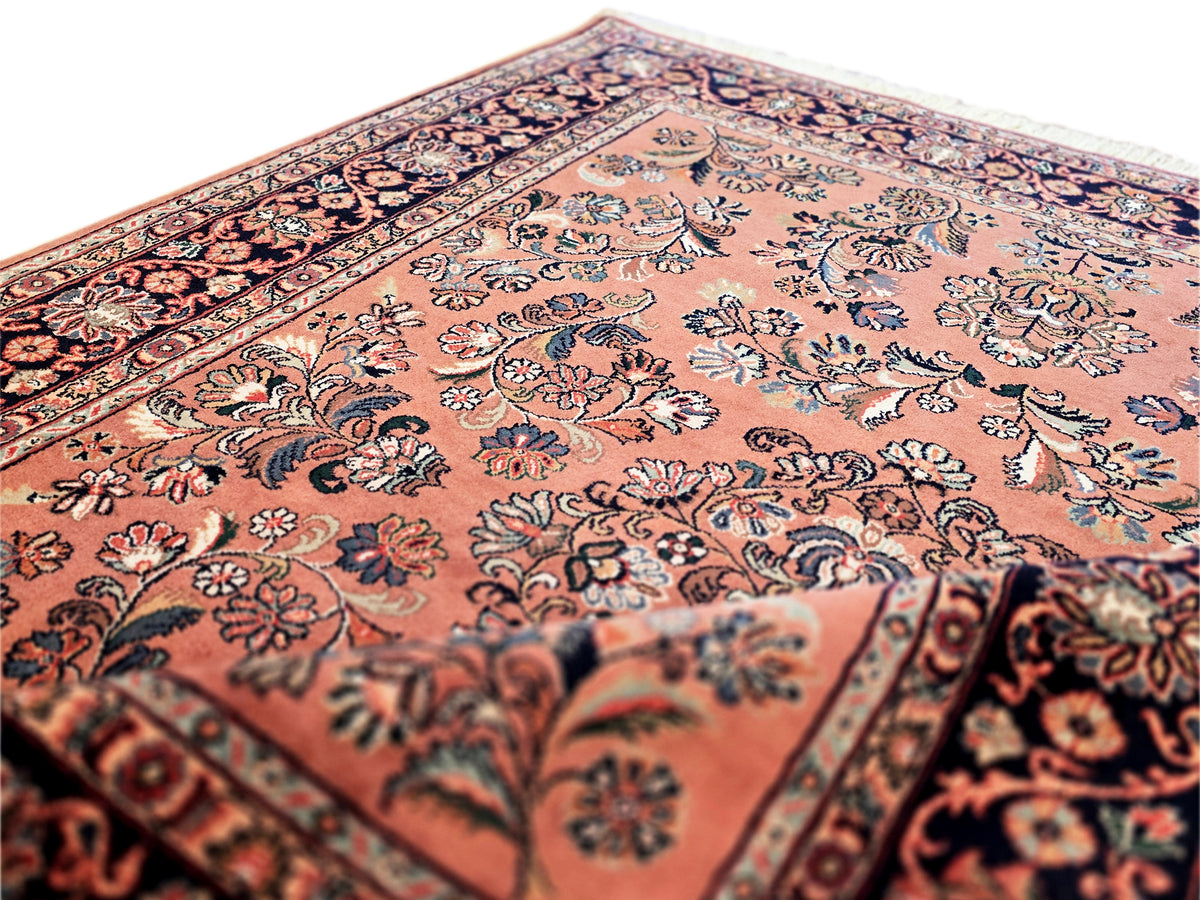 Floral-patterned area rug in rust and navy with detailed border stripe