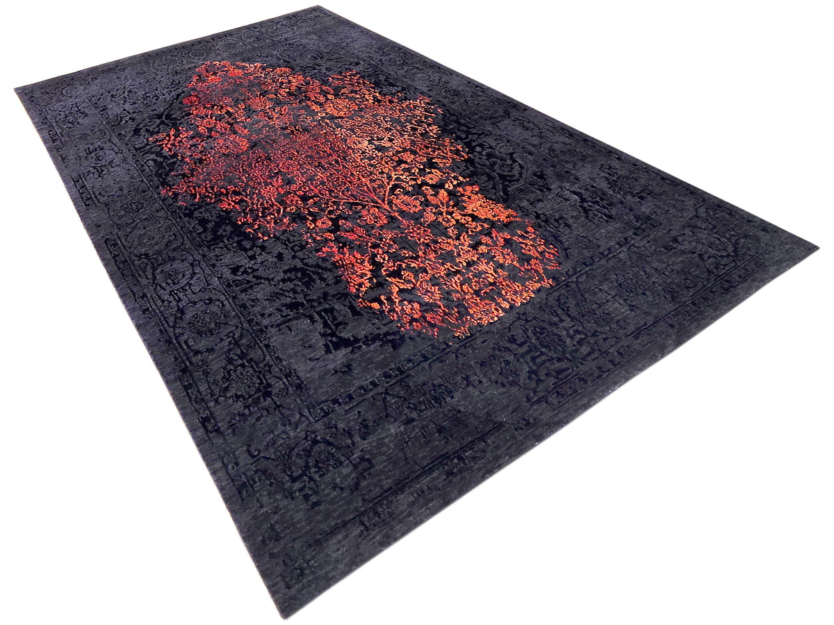 Navy area rug with orange-red central abstract design, flat lay on white background