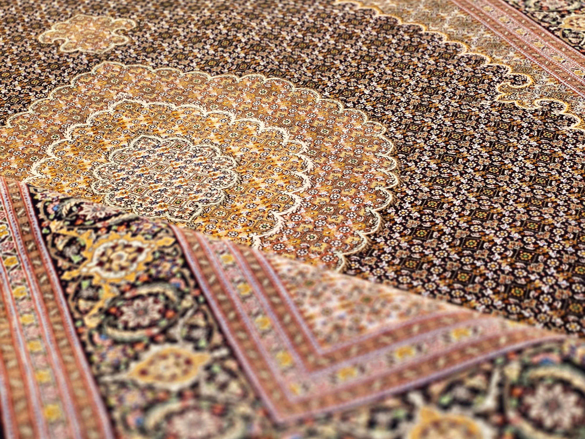 Close-up of dark rug with ornate gold medallion and red corner trim