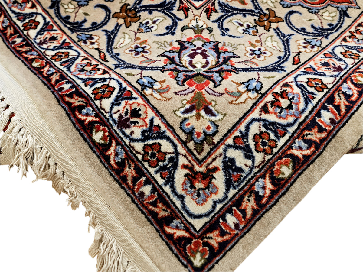 Esfahan perizisch rug corner detail with cream, red, and blue medallion motifs and fringe