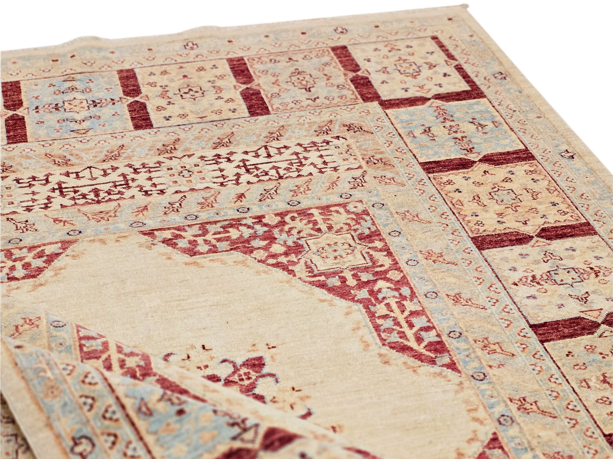 Ariana rug close-up with cream field, red block patterns, and light blue accents on border.