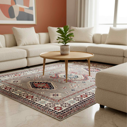 Kazak rug in living room, beige-gray with red and navy geometric motifs and fringed edge